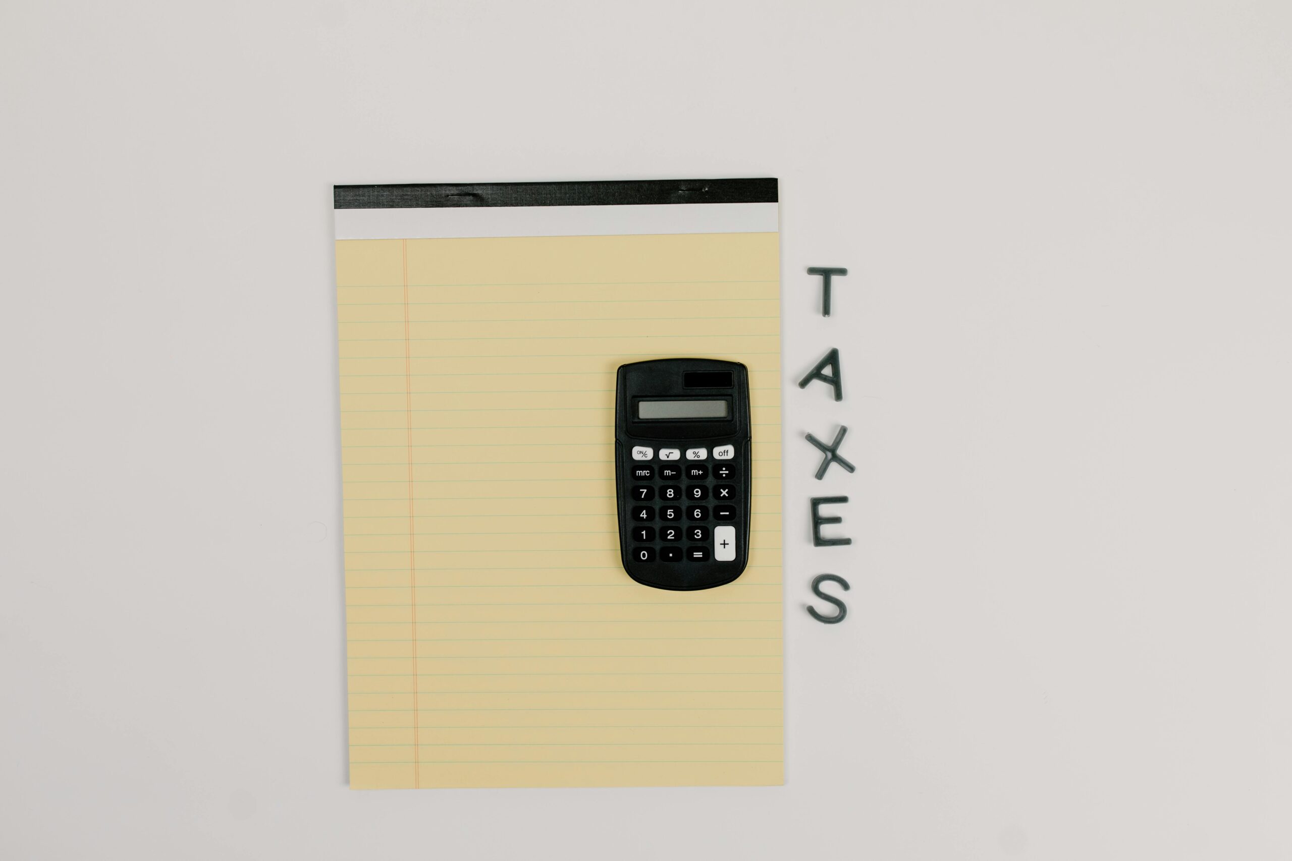 Calculator on paper with "taxes" text on the right side.